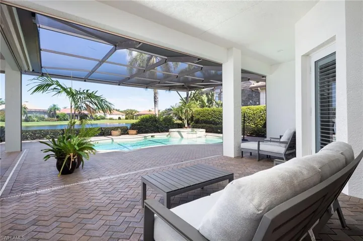 View of patio / terrace with a lanai, a pool with connected hot tub, and an outdoor hangout area
