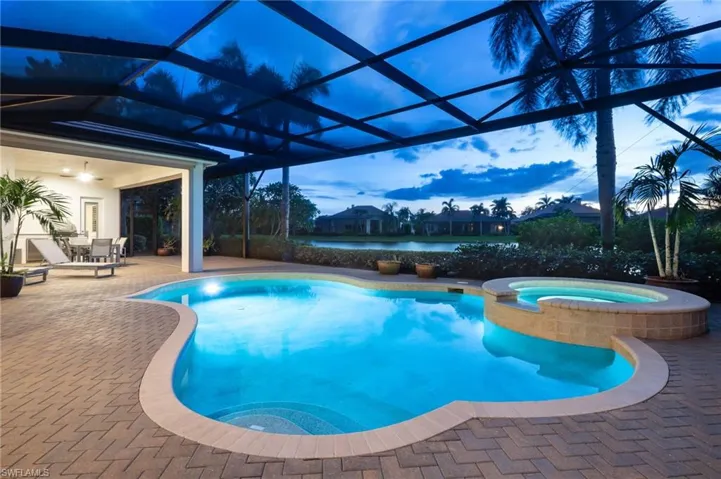 View of pool with a patio, a pool with connected hot tub, and a lanai