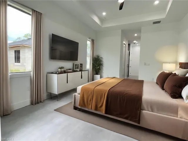 Bedroom featuring ceiling fan and a tray ceiling