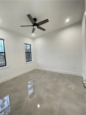 Spare room with concrete flooring and ceiling fan