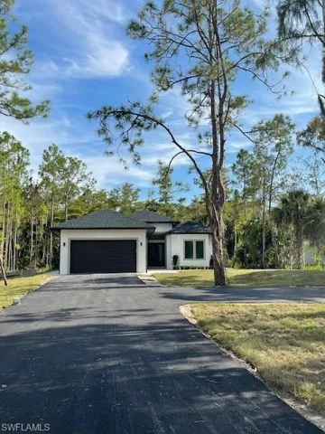 View of front of house featuring a garage and a front lawn