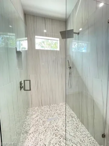 Bathroom featuring a wealth of natural light and tiled shower
