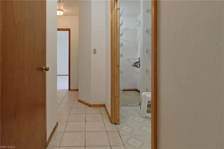 Corridor featuring light tile patterned floors and baseboards