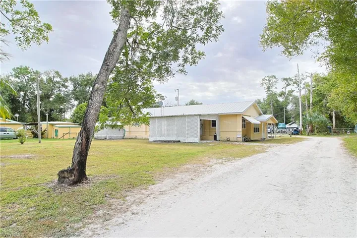 View of front of property with a metal roof and driveway