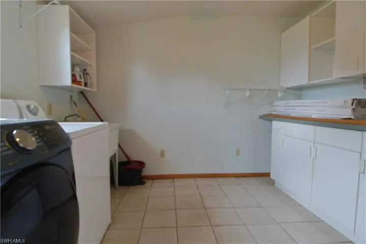 Washroom featuring washer / dryer and light tile patterned floors