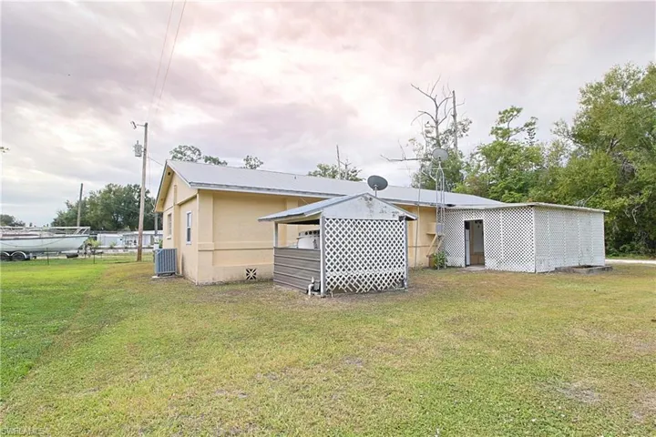 Back of property featuring a yard and a metal roof