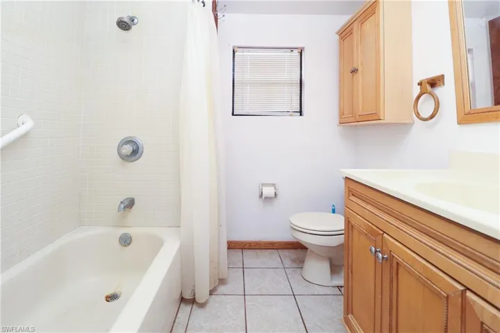 Full bathroom featuring light tile patterned floors, vanity, and shower / tub combo