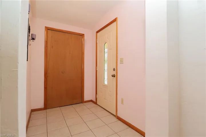 Entryway with light tile patterned floors and baseboards