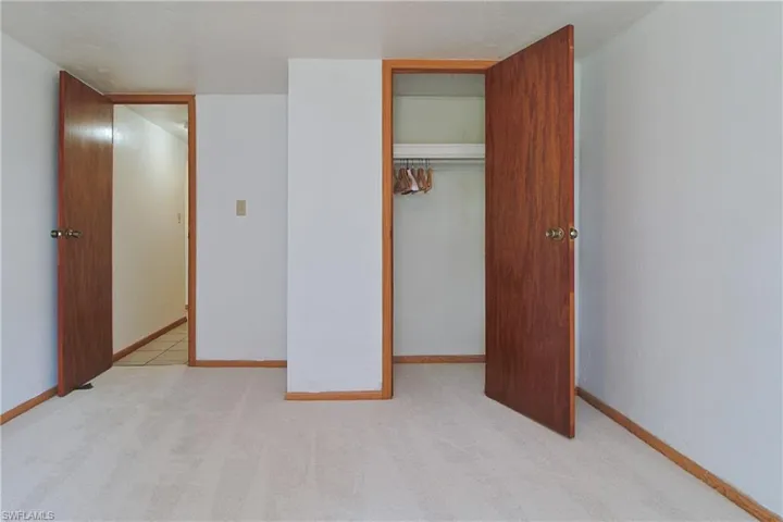 Unfurnished bedroom featuring light colored carpet and a closet
