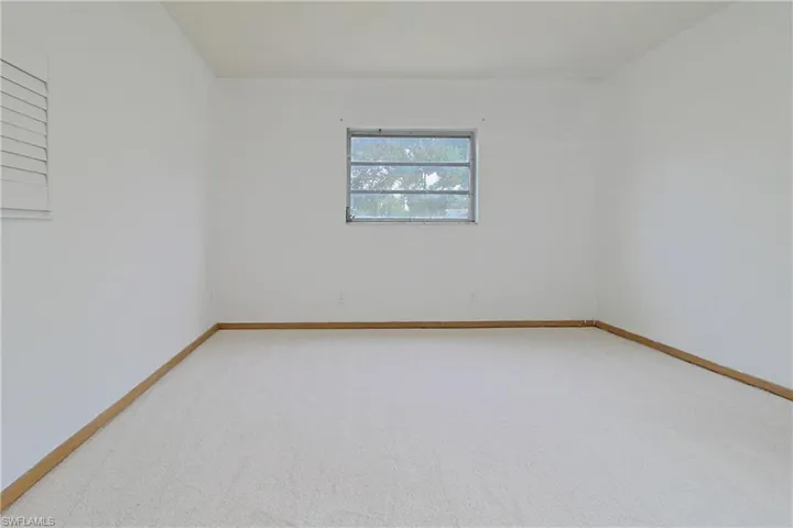 Unfurnished room with light carpet and baseboards