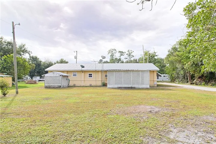 Rear view of property featuring a lawn and a metal roof