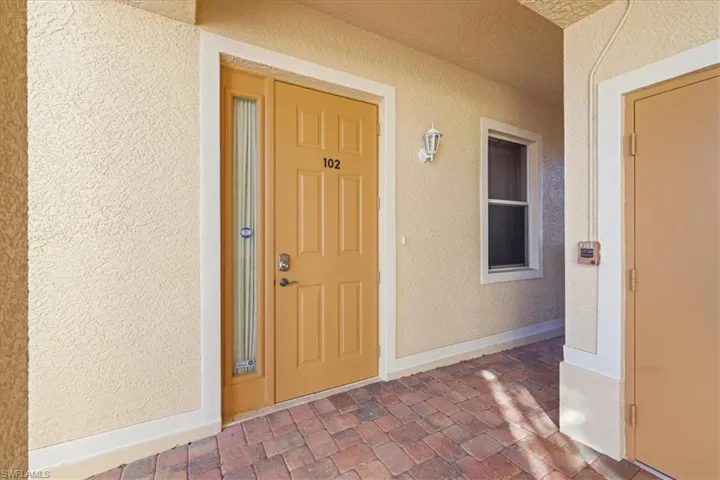 View of exterior entry featuring stucco siding and covered porch