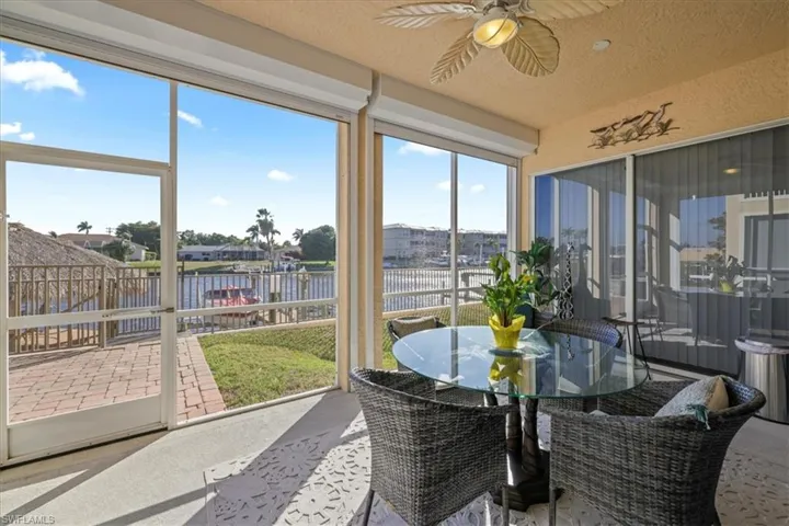 Sunroom / solarium with a water view and a textured ceiling