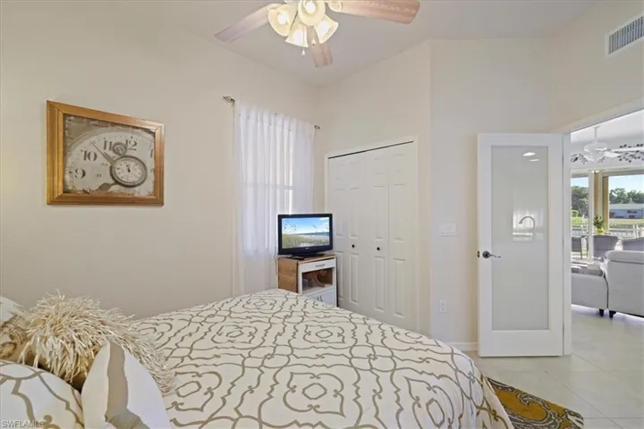 Bedroom with a closet, ceiling fan, and light tile patterned flooring