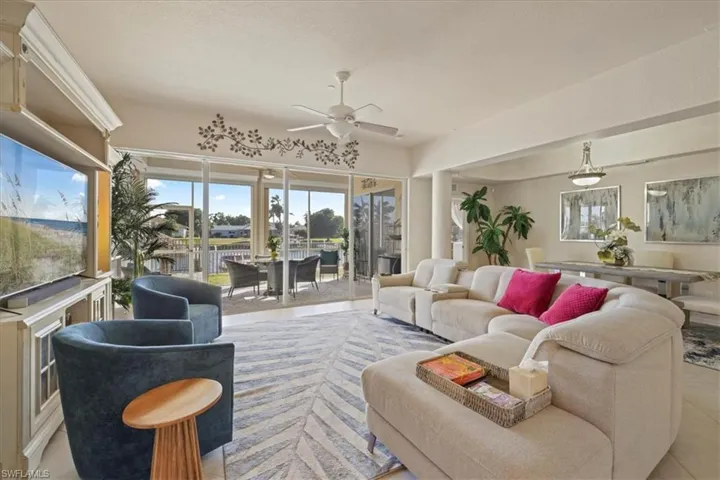 Tiled living room with ceiling fan and healthy amount of natural light
