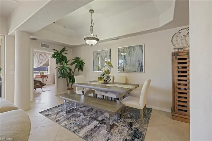 Dining room featuring a raised ceiling and light tile patterned floors