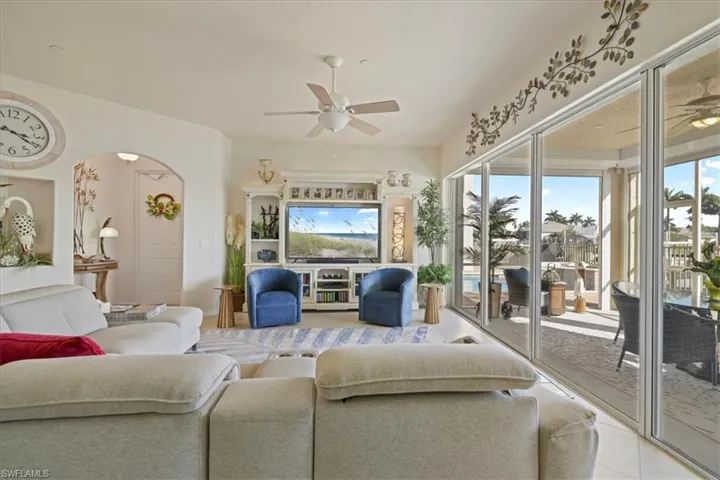 Living area featuring ceiling fan and arched walkways