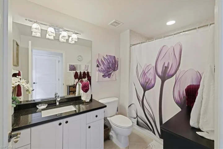 Bathroom with a shower with curtain and vanity