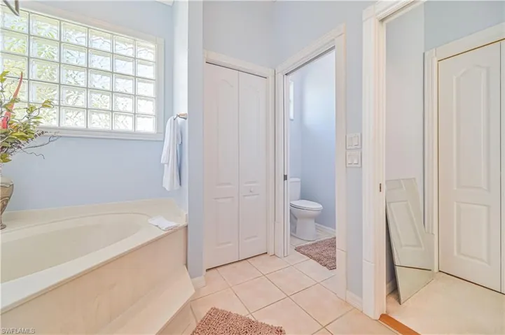 Bathroom with tile patterned floors, toilet, and a bath