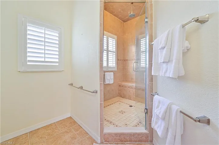 Bathroom featuring a shower with shower door and tile patterned floors