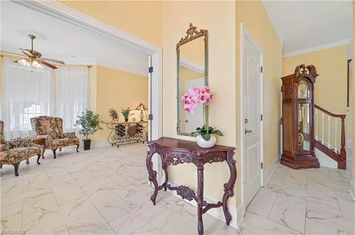 Corridor with light tile patterned floors and crown molding