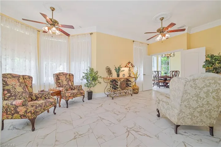 Sitting room featuring tile patterned flooring, crown molding, and ceiling fan