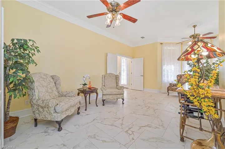 Sitting room featuring crown molding, ceiling fan, and light tile patterned floors