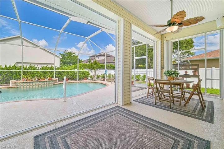 View of swimming pool featuring ceiling fan, a patio area, and a lanai