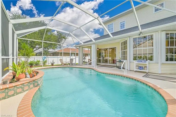View of swimming pool with a patio and a lanai