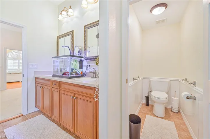 Bathroom with vanity, toilet, and tile patterned floors