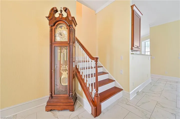 Staircase featuring light tile patterned flooring and ornamental molding