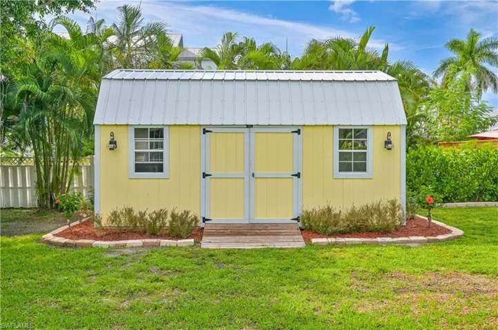 View of outdoor structure with a lawn
