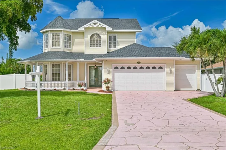 View of front facade featuring a porch, a garage, and a front lawn
