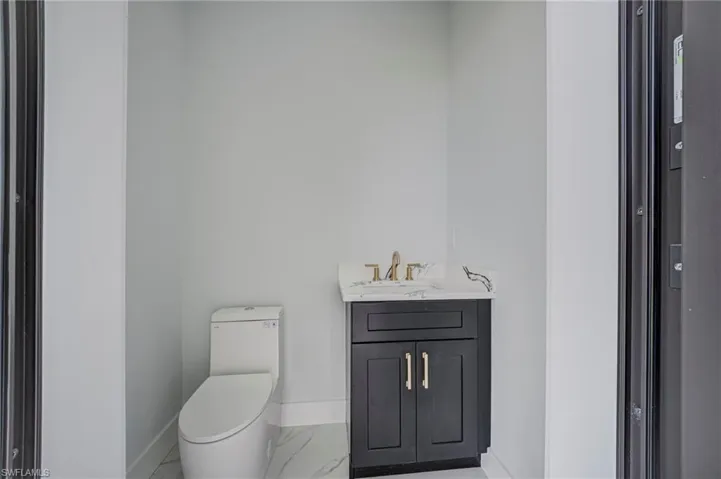 Bathroom with vanity and light marble finish floors