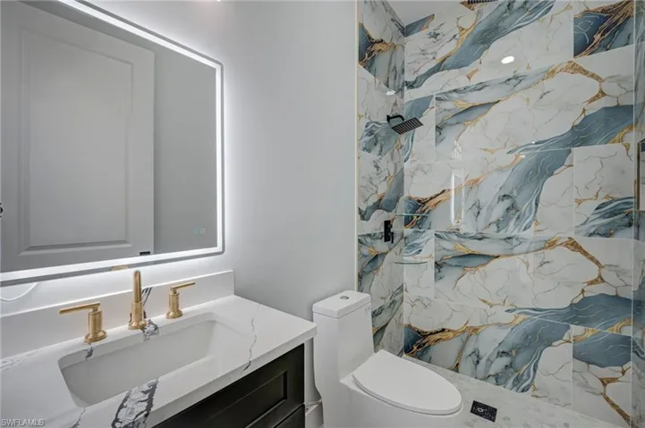 Full bathroom with vanity and a marble finish shower