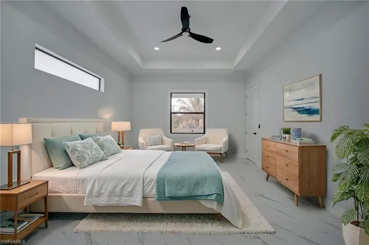 Bedroom featuring ceiling fan, recessed lighting, a tray ceiling, and light marble finish floors