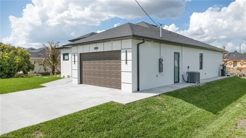 View of home's exterior with a lawn, a shingled roof, a garage, concrete driveway, and stucco siding