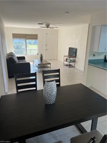 Dining area with ceiling fan, light tile patterned flooring, and baseboards