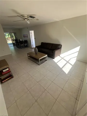 Living room featuring ceiling fan, visible vents, and light tile patterned flooring