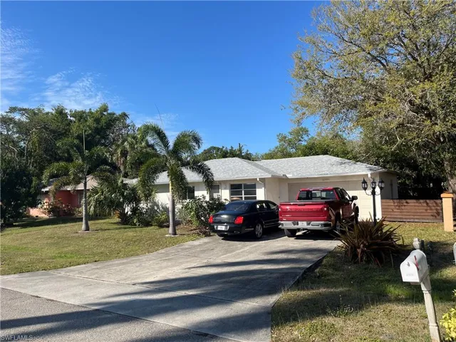 Ranch-style house with an attached garage, driveway, and a front lawn