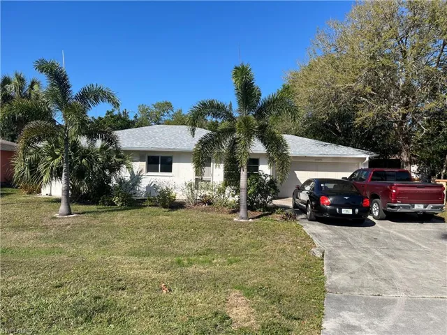 Single story home with a front yard, driveway, and an attached garage