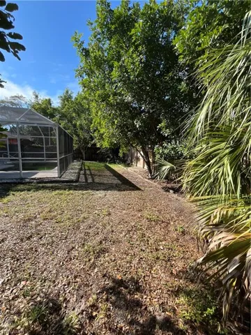 View of yard with a lanai and fence