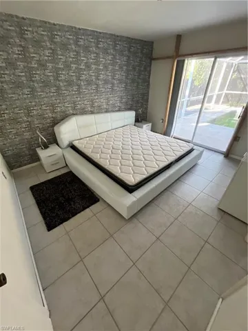 Unfurnished bedroom with tile patterned floors and access to exterior