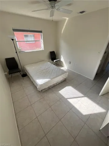 Unfurnished bedroom with tile patterned flooring, visible vents, and ceiling fan