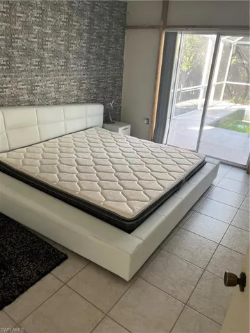 Unfurnished bedroom with access to exterior and tile patterned flooring
