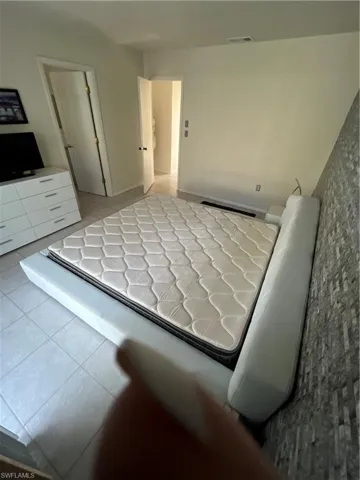 Bedroom with light tile patterned flooring and visible vents