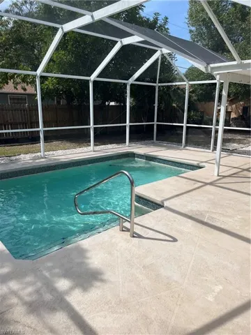 View of swimming pool with a fenced in pool, a patio, glass enclosure, and a fenced backyard