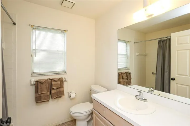 Bathroom featuring vanity, toilet, and curtained shower