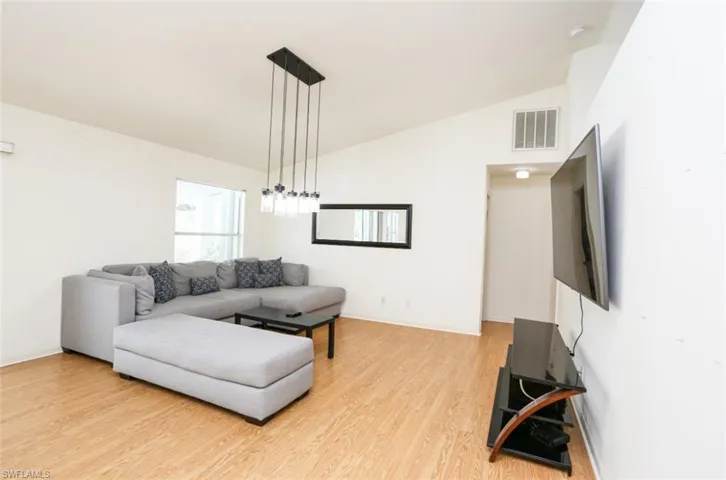 Living room featuring hardwood / wood-style floors and lofted ceiling