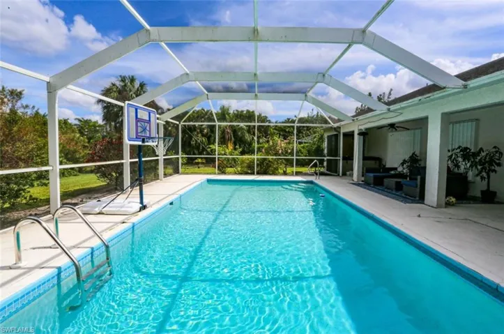 View of pool with ceiling fan, a lanai, and a patio